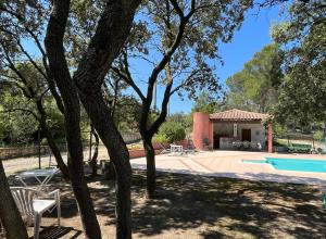 a villa with a pool and a house at La Pujauline in Pujaut