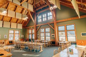 a dining room with tables and chairs and windows at Highland Center in Bretton Woods