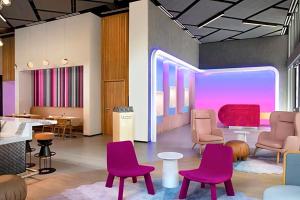 a waiting room with purple chairs and tables at Stylish Stay in the Heart of Miami - Walk to Bayside & Bayfront Park in Miami