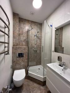 a bathroom with a shower and a toilet and a sink at Dominican in Lviv