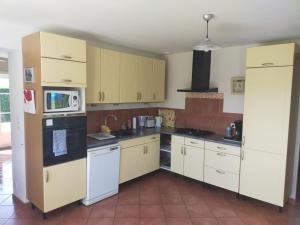 a kitchen with white appliances and yellow cabinets at Maison De La Fontaine Verte Proche Albi- Rodez- Carmaux in Carmaux