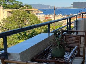 a bench on a balcony with a potted plant at Villa Konstantina in Tolo