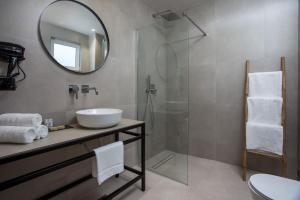 a bathroom with a sink and a shower with a mirror at Pado Living in Faliraki +37 photos