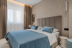 a bedroom with a large bed with blue pillows at Luxury Apartment & Rooms "Diva West & East" in Split