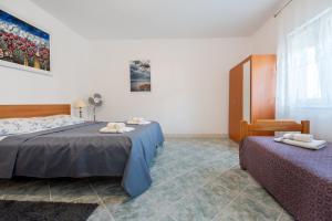 a bedroom with two beds and a chair in it at Holiday Home Casa Blu near the Beach in Neum