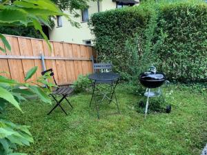 a barbecue grill and two chairs in a yard at Ferienwohnung Rosa in Fritzens