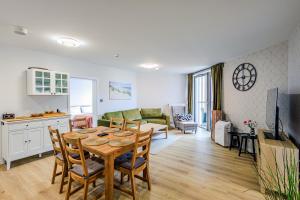 Una cocina y una sala de estar con mesa y sillas. en PINEA Apartamenty, en Pobierowo