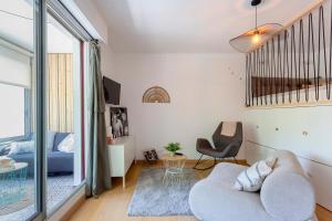 ein Wohnzimmer mit einer Couch und einem Sessel in der Unterkunft Chez Stéphanie De - Superbe studio design en centre ville avec piscine in La Grande-Motte