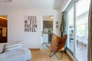 ein Wohnzimmer mit einer Couch und einem Sessel in der Unterkunft Chez Stéphanie De - Superbe studio design en centre ville avec piscine in La Grande-Motte + 13 Fotos