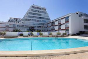 einem Pool vor zwei Gebäuden in der Unterkunft Chez Stéphanie De - Superbe studio design en centre ville avec piscine in La Grande-Motte