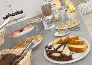 a table topped with plates of bread and pastries at Hotel Ariva in Rimini