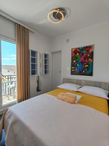 a bedroom with a large bed with a painting on the wall at Guest House Lara in Neum