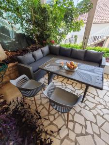 a patio with a couch and a table and chairs at Guest House Lara in Neum
