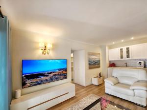 a living room with a large flat screen tv on the wall at Luxury unique central flat with 2 swimming pools in Playa de las Americas