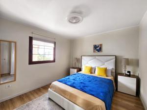 a bedroom with a large bed with blue sheets and yellow pillows at Luxury unique central flat with 2 swimming pools in Playa de las Americas +17 photos