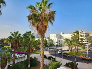 a view of a city with palm trees and cars at Luxury unique central flat with 2 swimming pools in Playa de las Americas
