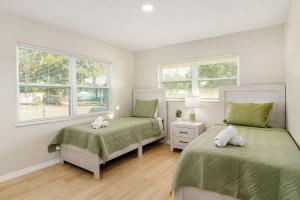 泽弗希尔斯Spacious Duplex Zephyrhills #2的有两张床和两扇窗户的卧室