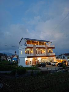 a large building with cars parked in a parking lot at M2 Homestay Berastagi in Berastagi