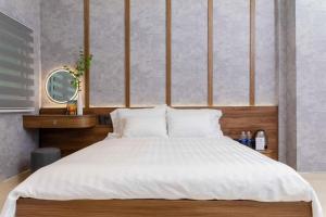 a bedroom with a large bed with white sheets at Ari Boutique Hotel in Ho Chi Minh City