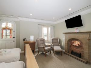 a living room with a fireplace and a tv at Harcombe House Rooms Accessible Ground Floor Twin in Newton Abbot +29 photos