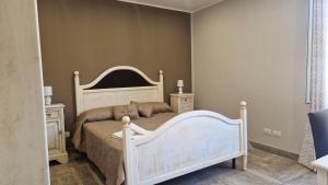 ein Schlafzimmer mit einem weißen Bett und zwei Nachttischen in der Unterkunft Giully's Rooms in Catania