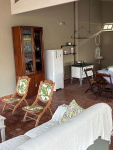 un soggiorno con divano e sedie e una cucina di Casa Região Privilegiada próx. ao Centro e Clube Campo. a Joanópolis