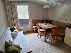 a room with a table and a bed and a table and chairs at Ferienwohnung Rüf in Bizau