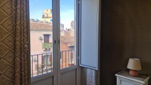ein offenes Fenster mit Blick auf ein Gebäude in der Unterkunft Giully's Rooms in Catania