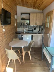 a kitchen and dining room with a table and chairs at Sosnowy Raj - domki na Mazurach in Maradki
