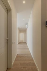 an empty hallway with white walls and wood floors at Gatve apartment in Rīga