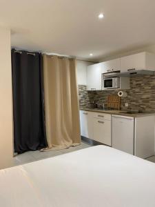 a kitchen with curtains in the middle of a room at Homevasion La Cherry in Le Diamant +2 photos