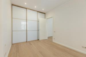 an empty room with white walls and wooden floors at Gatve apartment in Rīga