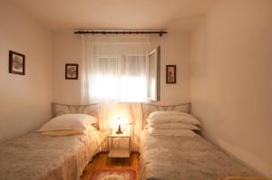 two twin beds in a room with a window at Apartment Agata in Splitska