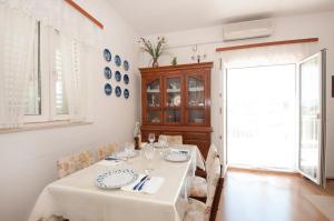 a white dining room with a table and chairs at Apartment Agata in Splitska