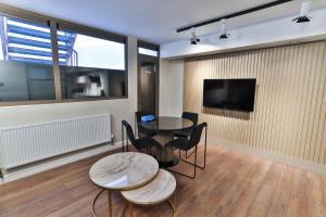 a living room with a table and chairs and a tv at Goodwin St in London