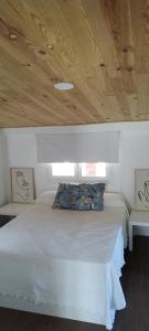 una camera da letto con un letto bianco con un soffitto in legno di Balcón de Granada Skyline a Las Gabias