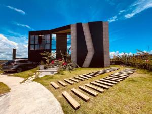 a house with a bench in front of it at Casa Pillar - Casa de Alto Padrão em Ilhéus in Ilhéus