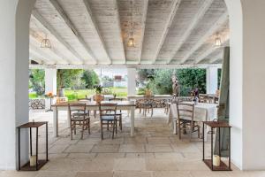an outdoor dining area with tables and chairs at L'aia di San Giorgio in Ortelle