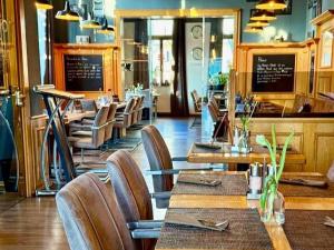 a restaurant with wooden tables and chairs and a counter at Hotel Artushof in Dresden