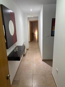 a hallway with a long room with a mirror at Pool Center in Caudete