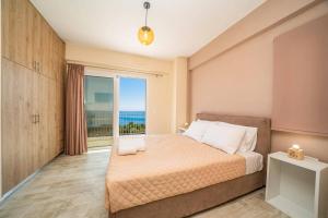 a bedroom with a bed with a view of the ocean at Villa Prasino by Villa Plus in Plateies +20 photos