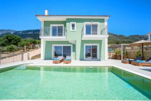 a villa with a swimming pool in front of a house at Villa Prasino by Villa Plus in Plateies