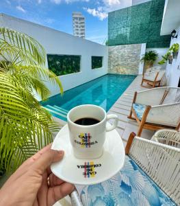 a person holding a cup of coffee on a patio at Le MARIE B&B in Cartagena de Indias