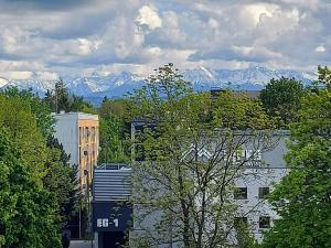 ノヴィ・タルクにあるApartament 14 Nowy Targ - słoneczny apartament z widokiem na Tatryの山々を背景に通りを走る列車