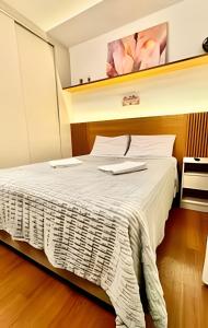 a bedroom with a large bed with white sheets at O melhor no edifício PRiNCESS in Curitiba