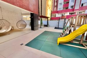 a balcony with a yellow chair and a slide at O melhor no edifício PRiNCESS in Curitiba