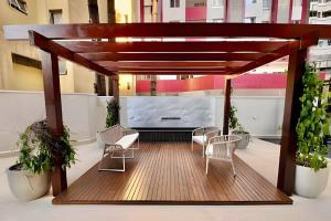 a pergola on a balcony with chairs and plants at Vivendo o Melhor de Curitiba in Curitiba
