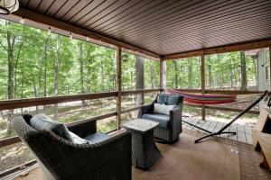 a screened in porch with chairs and a hammock at Dog-Friendly w Hot Tub, Fire Pit & River Access in Great Cacapon