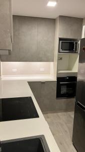 a kitchen with a white counter top and a microwave at Habitación central Viña Centro, barrio Poniente in Viña del Mar
