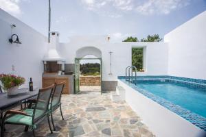 une villa avec une piscine et une table et des chaises dans l'établissement Nouvelle15 Cozy House with Private Pool, à Koskinou